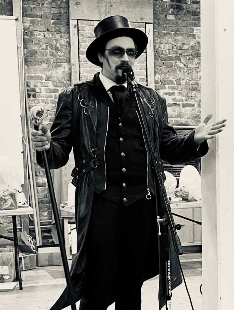 A man holding a cane with heavy makeup in front of a microphone